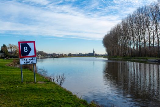 Straatbeeld in Boxmeer met wolkenlucht en fietsers, passend bij weer Boxmeer per uur